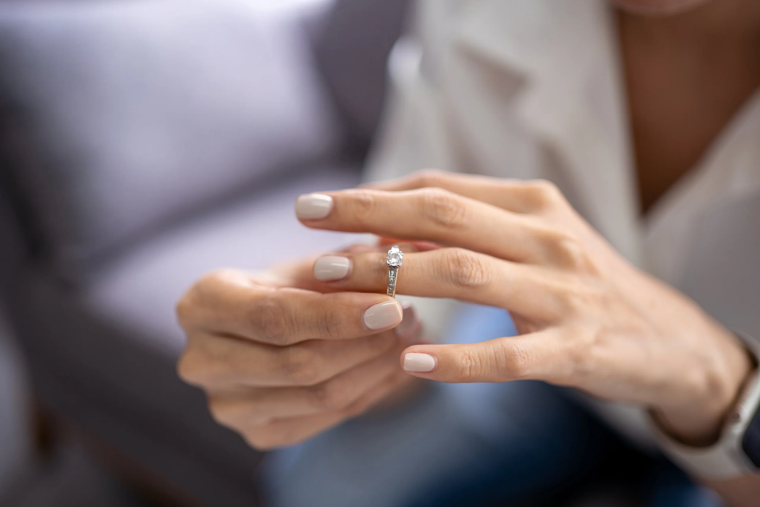 A woman removes her wedding ring from her left ring finger