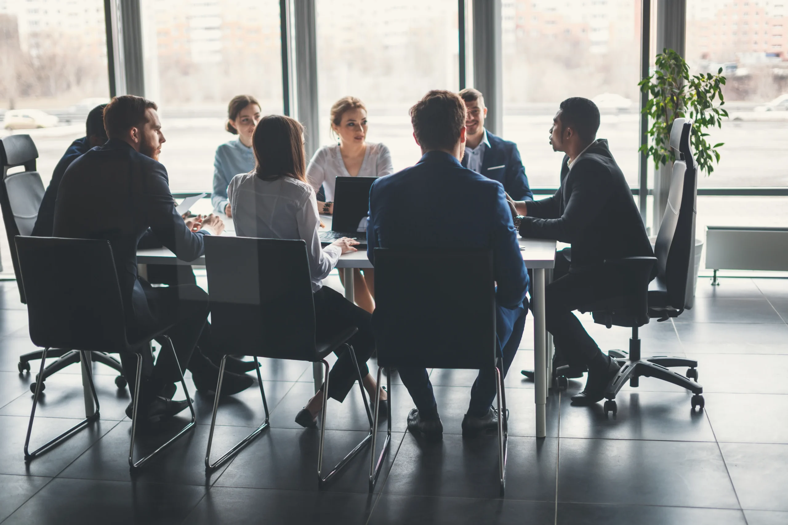 A group of business people sit around a conference table discussing